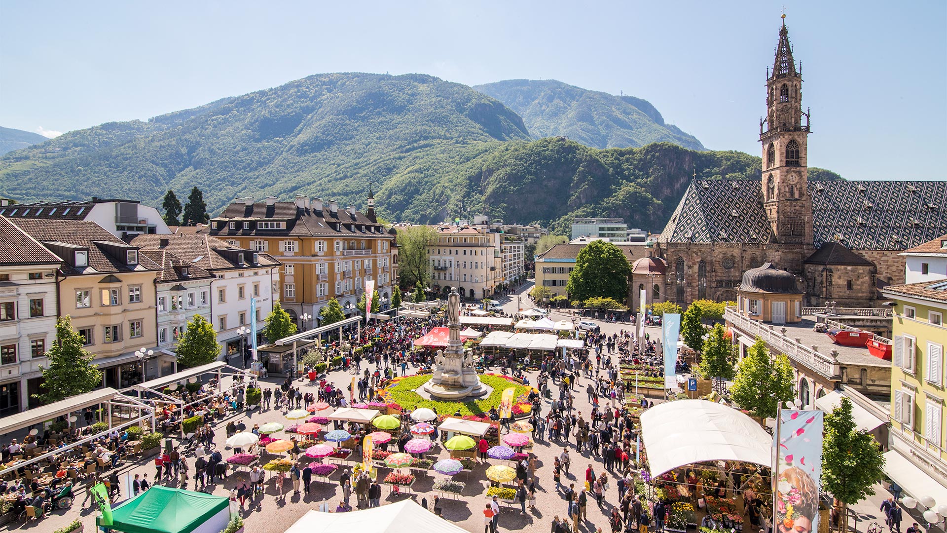 View from above of Piazza Walther, decorated with benches and umbrellas on a hot summer's day.