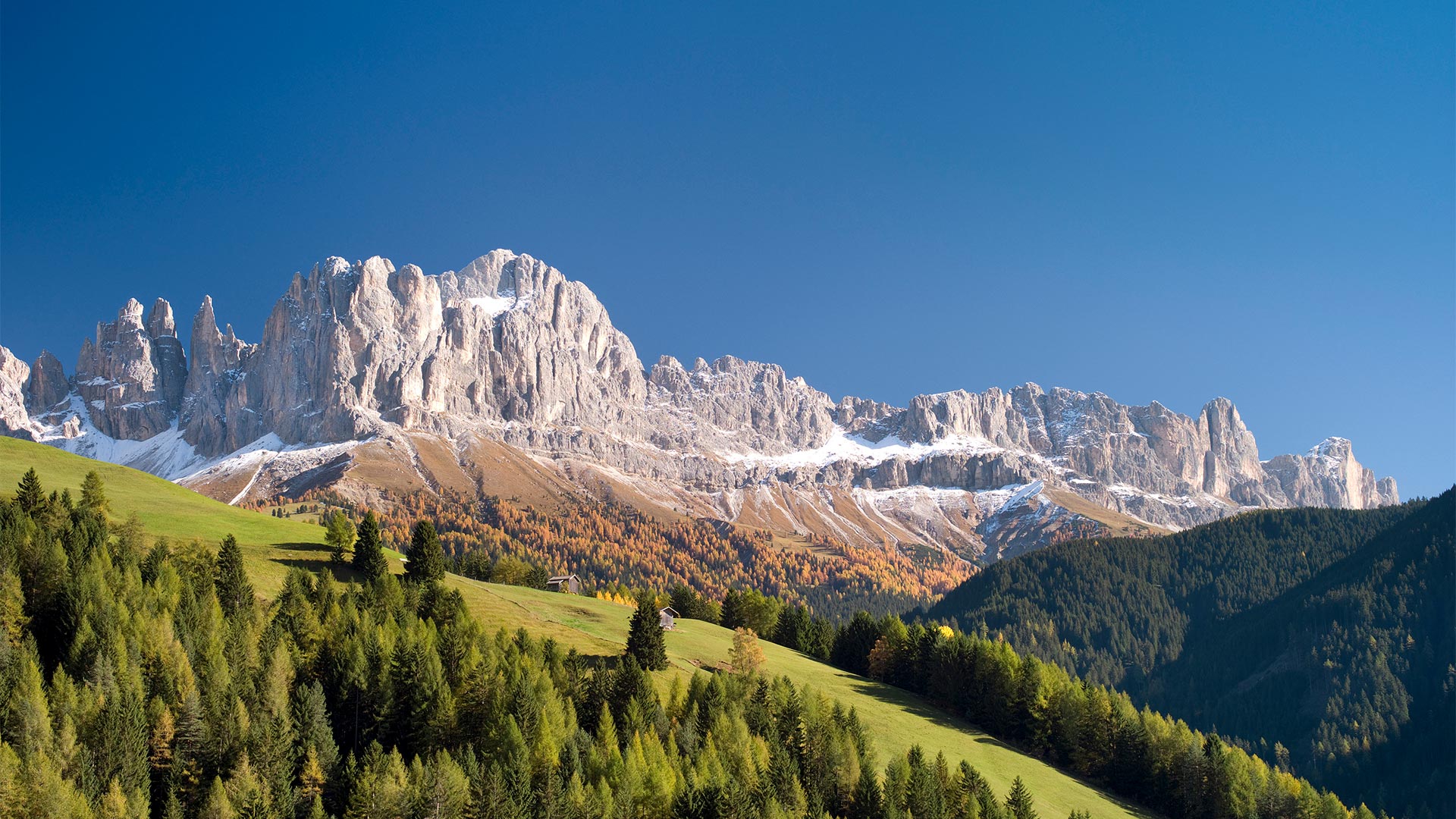 Vista panoramica dai prati verdi sulle Dolomiti di Bolzano in una giornata di sole.