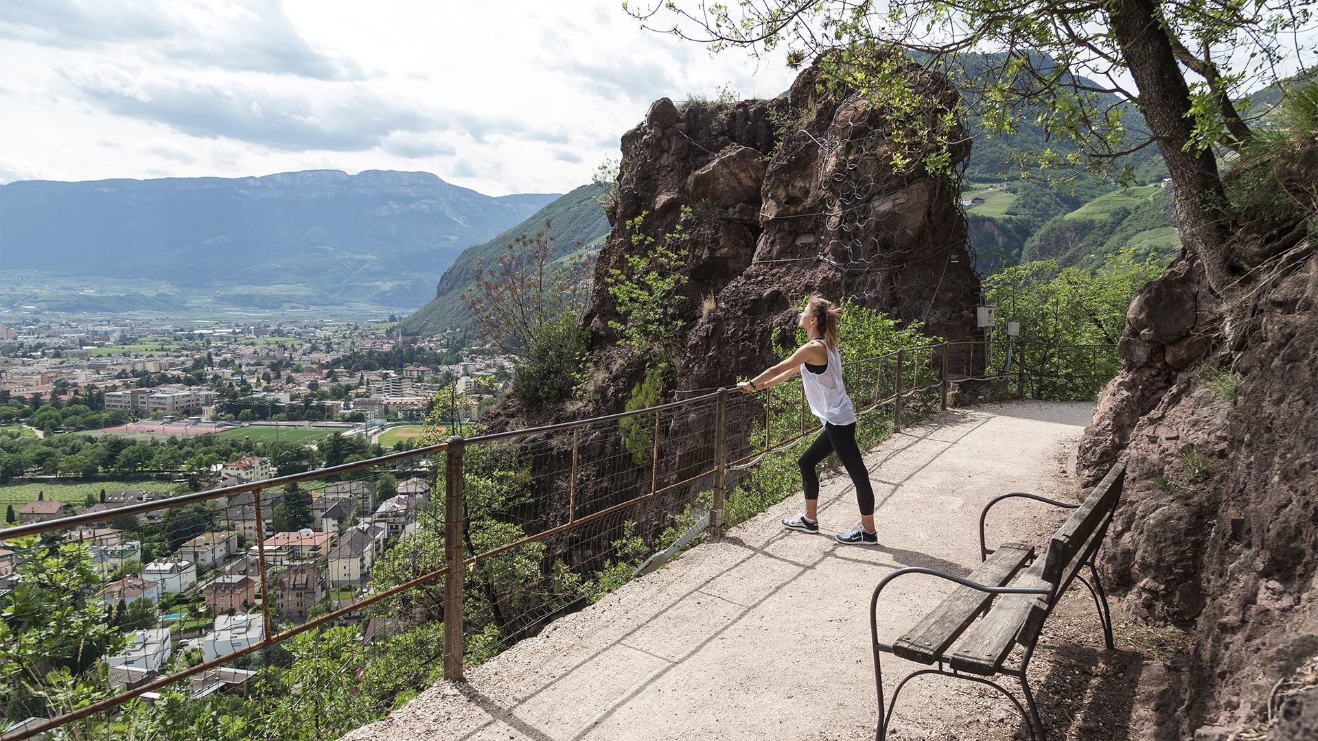 An einem Nachmittag in Bozen ruht sich ein junges Mädchen nach dem Laufen an der frischen Luft auf dem St. Oswald Promenade.