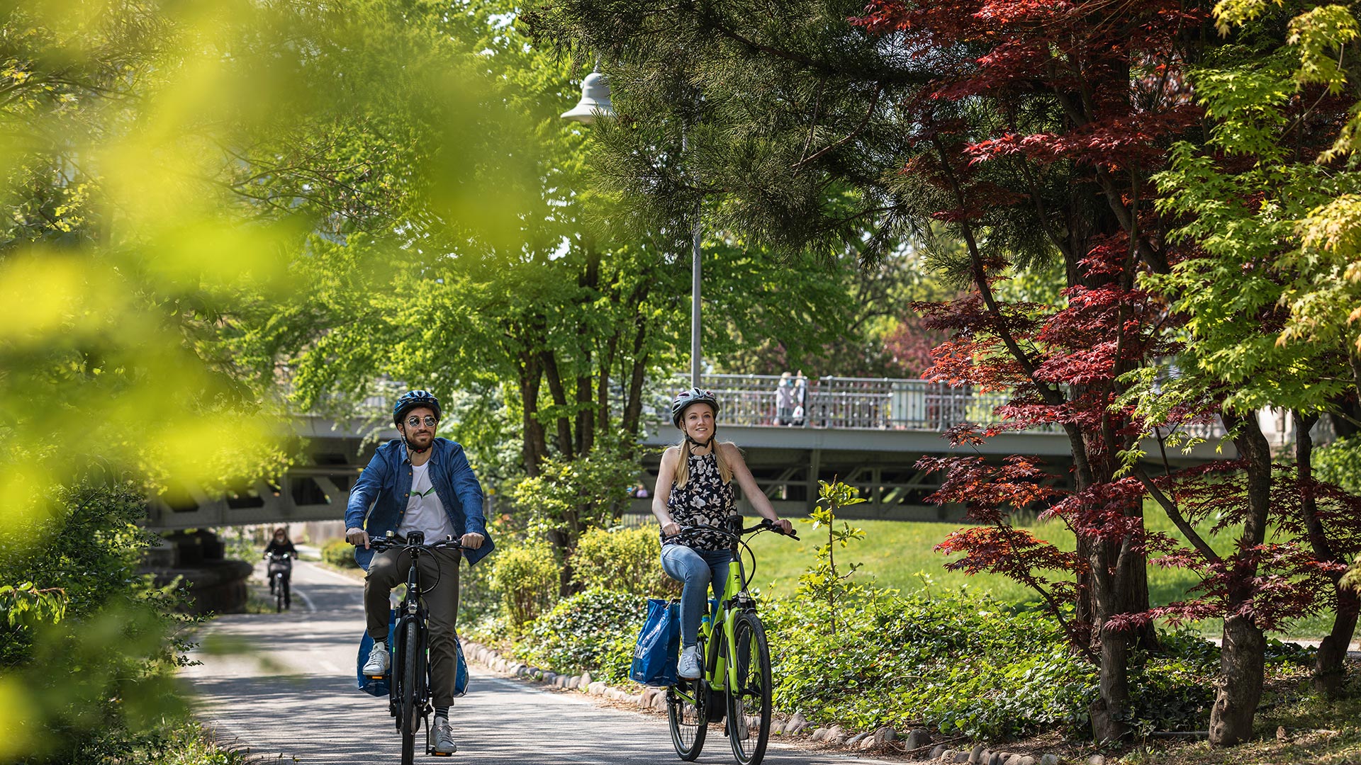 Ein Paar radelt auf dem Bozner Radweg in der Nähe der Talferwiesen.