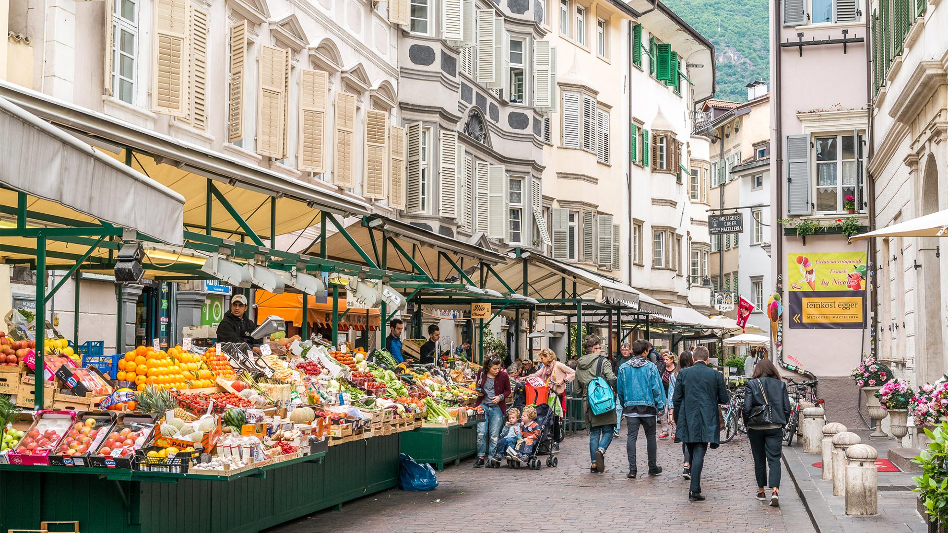 At Piazza Erbe citizens and tourists stop at the markets and fruit vendors to buy fresh local products.