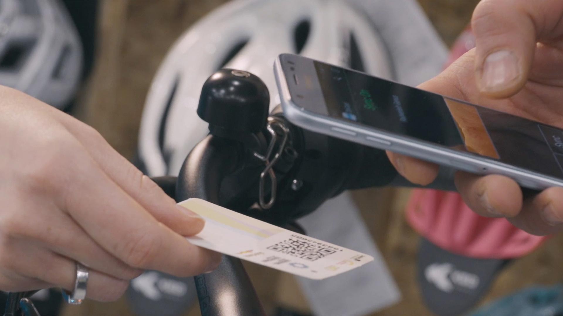 Ein Tourist scannt mit seinem Mobiltelefon den QR CODE auf der ihm ausgehändigten Guestcard, um die Dienstleistungen in Bozen zu aktivieren.
