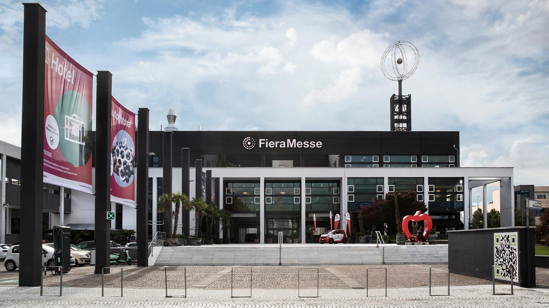 In una giornata nuvolosa, vista frontale della Fiera di Bolzano, luogo di eventi culturali e informativi e congressi.