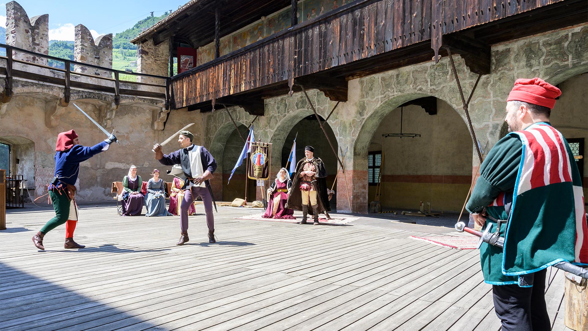 Bei einer kulturellen Veranstaltung unter freiem Himmel, bei der zwei Schauspieler in traditionellen Kostümen ein Duell austragen, können die Besucher mehr über die Geschichte und Kultur Bozens erfahren. 