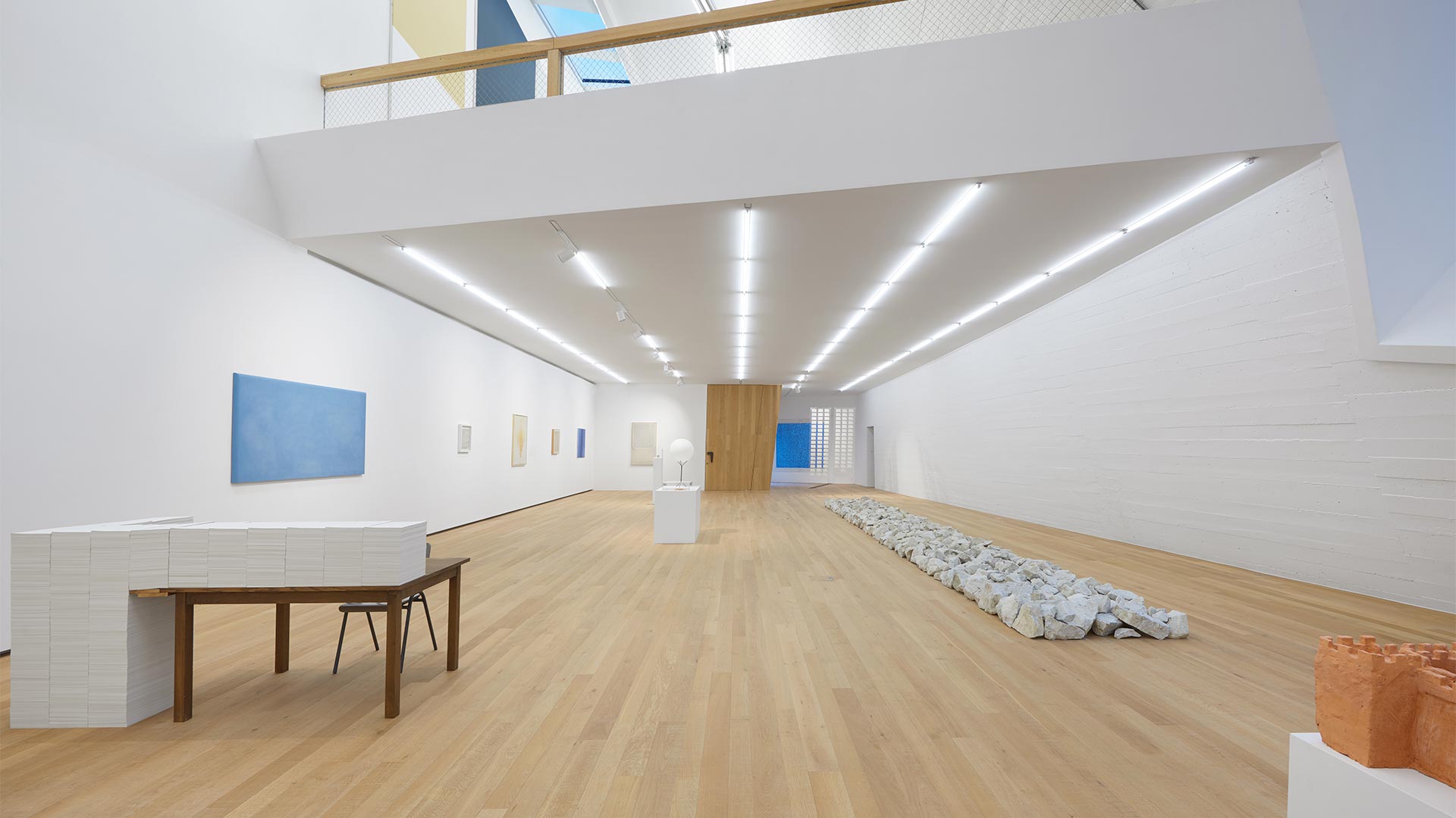 An LED-lit museum room, decorated with contemporary art paintings to welcome visitors.