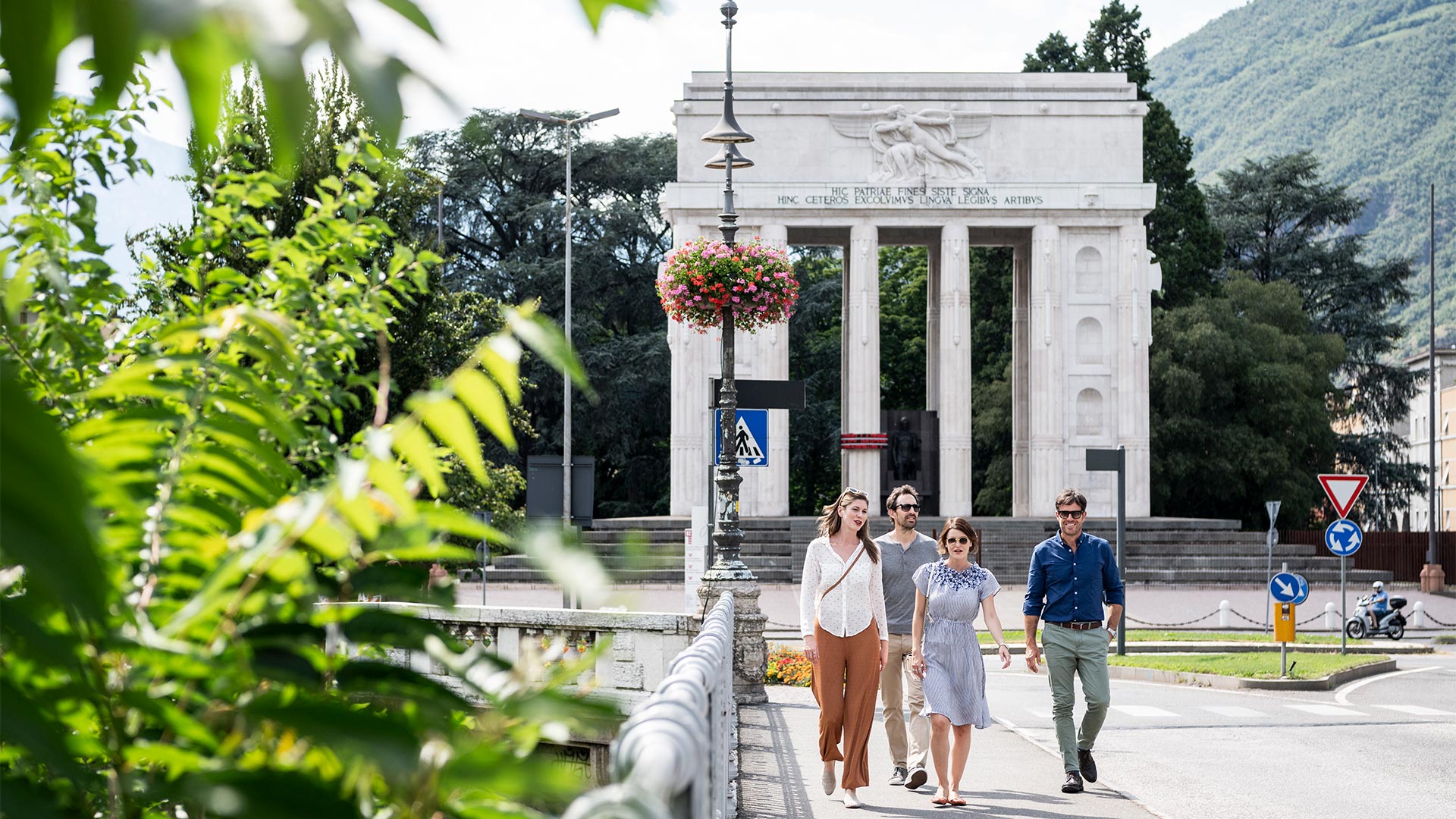 A group of friends has already passed Piazza Vittoria and is about to cross the Talvera Bridge.