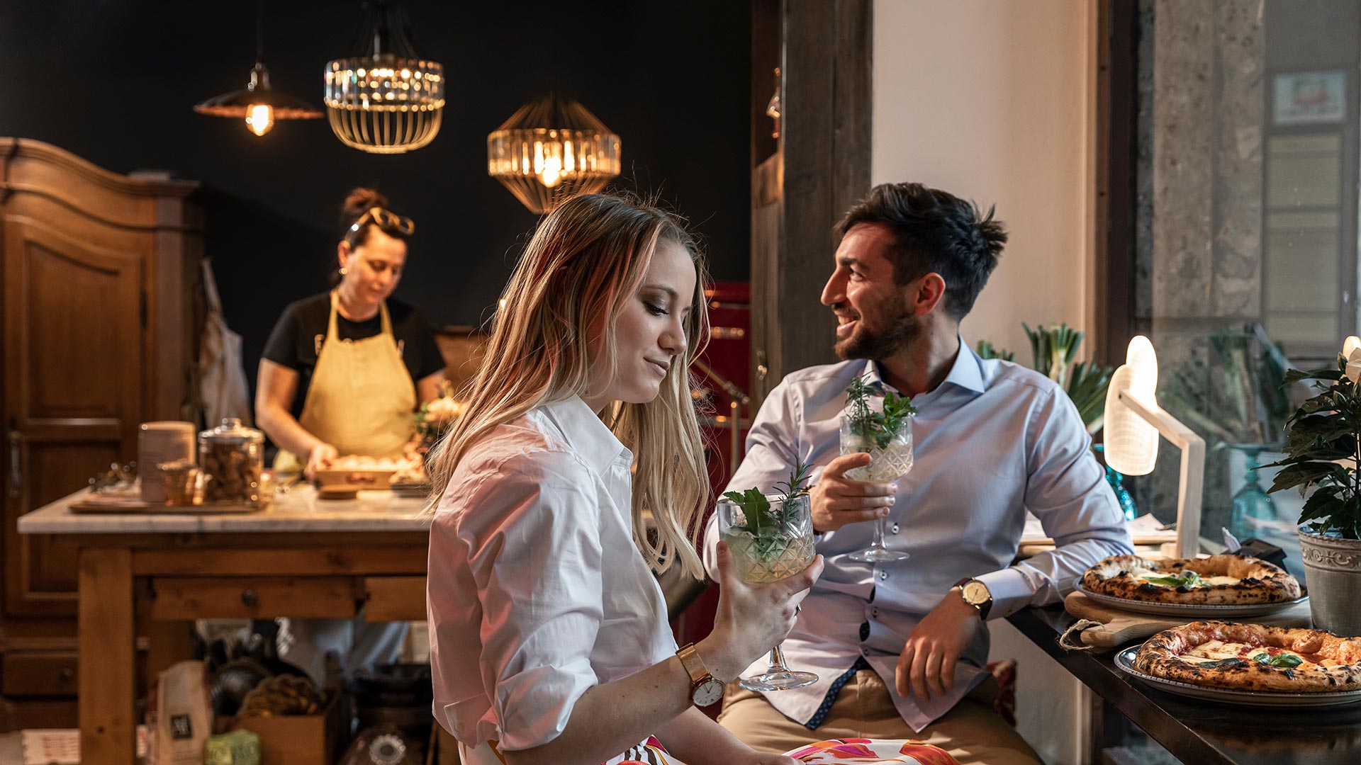 Zwei Freunde sitzen an einem Tisch in einem Restaurant in Bozen und trinken ein Glas Hugo als Aperitif .